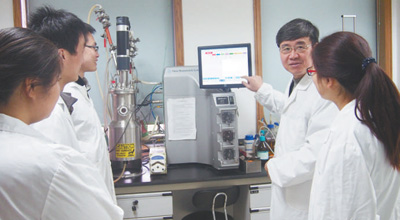 王一成（右二）在浙江省农业科学院畜牧兽医研究所向学生讲解干扰素发酵实验。